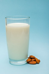 glass of almond milk on blue background