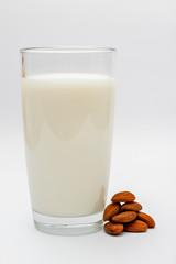 glass of almond milk on white background