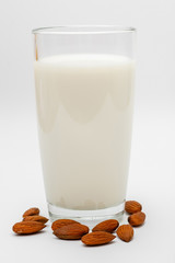 glass of almond milk on white background