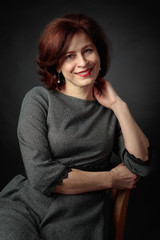 Portrait of happy woman in grey dress.