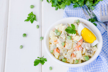 Russian traditional salad Olivier with vegetables and meat