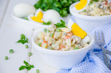 Russian traditional salad Olivier with vegetables and meat