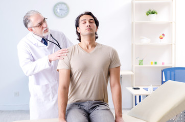 Obraz premium Young male patient visiting old doctor 