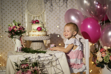 Fototapeta na wymiar child tastes cake decorated with lively flowers