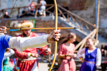 Fototapeta na wymiar A man shoots an bow. Medieval festival, entertainment_