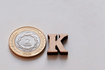 Close-up of the word OK made from 2 peso coins and wooden letters on a white background. Argentina...