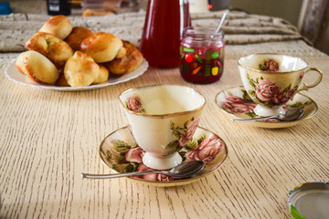 Tea with jam and cakes. Food and drinks on the dining table in different glass and ceramic dishes.