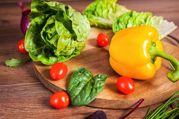 Yellow pepper and other vegetables on brown wooden background
