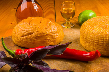 national Adyghe cheese homemade on a cutting Board with a knife, Basil, parsley, lime, sesame oil,...