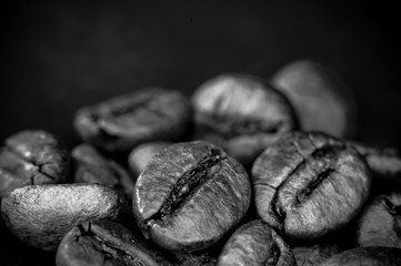 Brown roasted coffee beans on black background, close up, macro