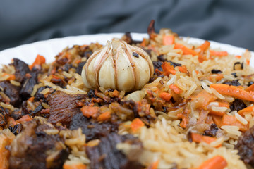 pilaf Uzbek close-up beautifully laid in a white plate
