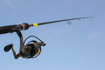 Fishing gear. Blue sky. Fishing with spinning.