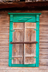 Closed shutters of carved window of wooden house in old russian style in Astrakhan
