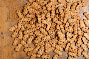 Composition of crackers with poppy seeds, spread out on a wooden background