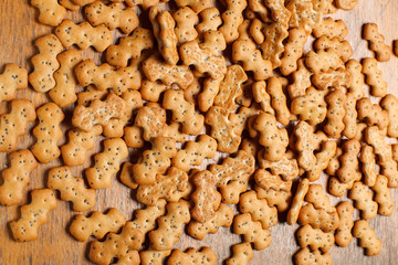 Composition of crackers with poppy seeds, spread out on a wooden background