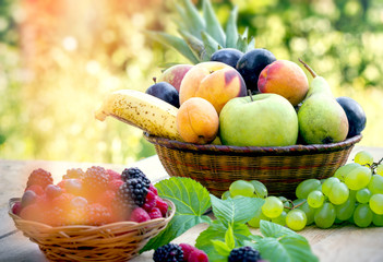 Healthy food, fresh organic fruit in wicker basket on table