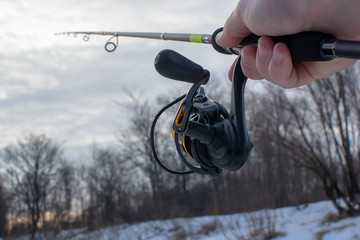 Fishing for spinning on a cloudy day. Spinning in the hand of the angler.
