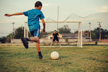 An action sport picture of a group of kids playing soccer football for exercise in the green grass...