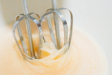 Sugar is mixed with beaten egg for dessert