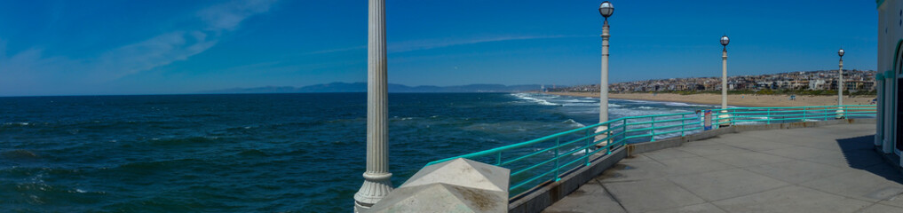 View of Southern California beach from pier on sunny day panorama