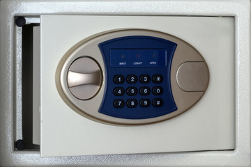 Combination lock on the open door of the safe box. The concept of keeping money in the bank, a small percentage, financial reliability and hotel security service.
