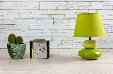 White Wooden Table with a Clock, a Lamp and a Cactus