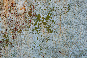 Background texture of old rusty damaged metal. Remains of multi-colored paint on an iron sheet.