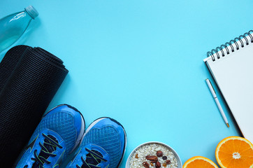 Fitness, healthy and active lifestyles Concept, sport shoes, bottle of waters, mat on blue background. copy space for text