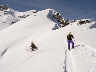 Young active man ski touring and staying at mountain peak background