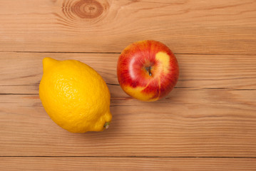 Lemon and apple on a wooden background. View from above .