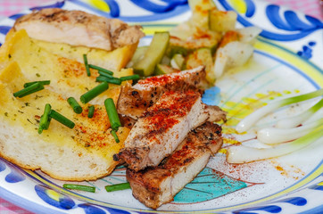Chicken breast sprinkled with paprika on garlic toast with cucumber salad and scallions.