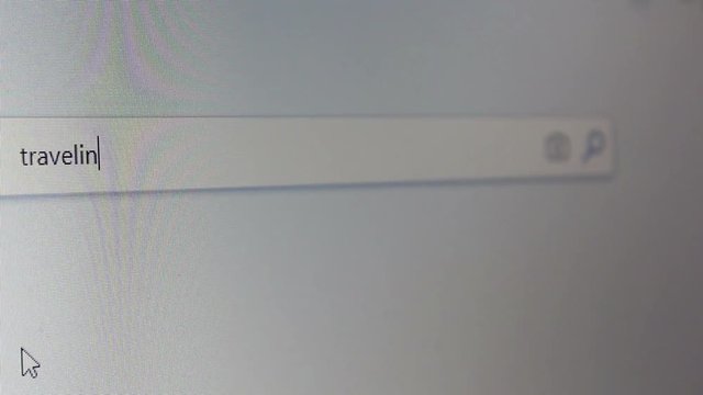 Internet user writes the word traveling in the search bar.Browser search bar.