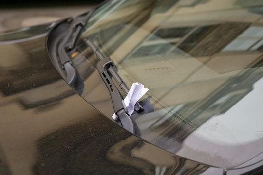 Parking ticket stuck on car windscreen for a penalty or fine.