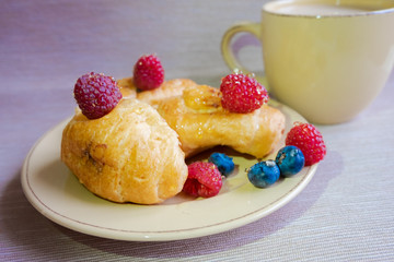 delicious summer juicy blueberry and raspberry berry with honey droplets on a fresh croissant