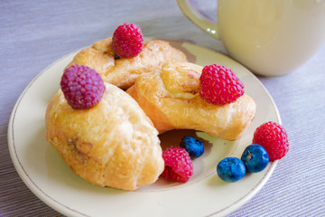 delicious summer juicy blueberry and raspberry berry with honey droplets on a fresh croissant