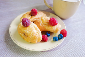 delicious summer juicy blueberry and raspberry berry with honey droplets on a fresh croissant