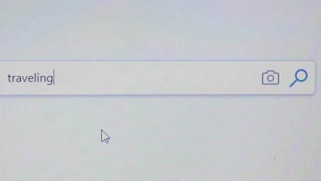 Internet user writes the word traveling in the search bar.Browser search bar.