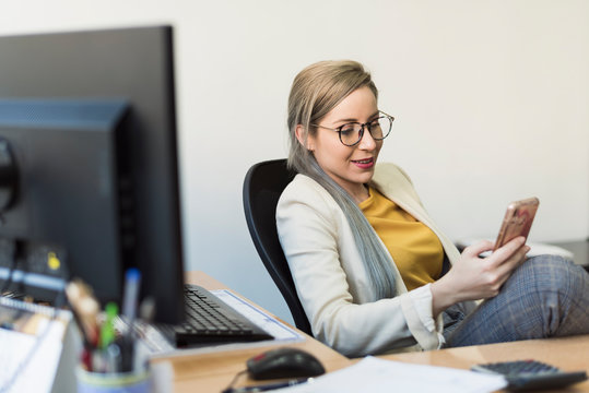 Young Woman Looking Smartphone At Work In A Break