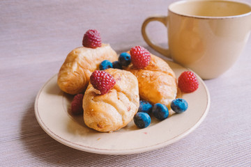 delicious summer juicy blueberry and raspberry berry with honey droplets on a fresh croissant