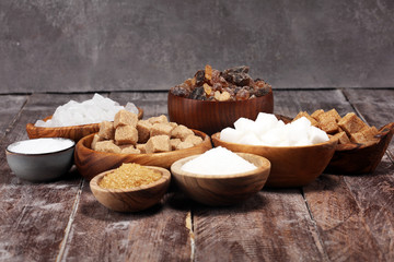 Various types of sugar, brown sugar and white on rustic wooden table