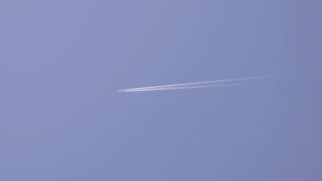 jet stream of airplane going in blue sky.