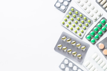 Pills in a blister on white top view.