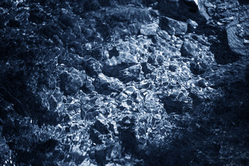 Rippled water with sun reflection. Water in a mountain river.