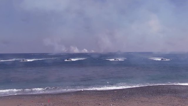  AAV 7A1 firing smoke grenades and arriving to the beach