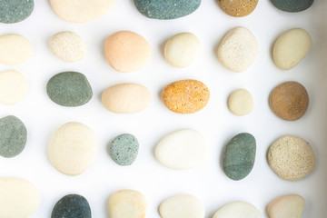 Different color and shape stone collection. Many kind of sea pebble with soft shadow. Regular pattern on white background. Abstract for design. wallpaper