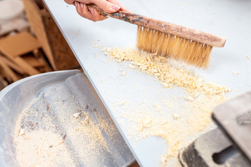 brush sweeping wood shavings in carpentry workshop