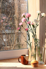 Spring flowers and a cup of coffee on a wooden background, the coziness of a new village house and a sunny bright morning