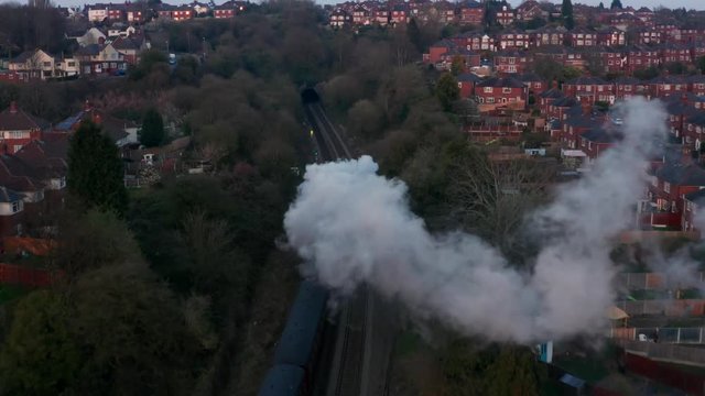 Flying through steam train steam near houses and town