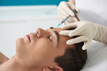 Man on facial beauty procedure in cosmetic center