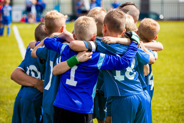 Group Of Children In Soccer Team. School Football Coach’s Pregame Speech. Coaching Youth Sports....